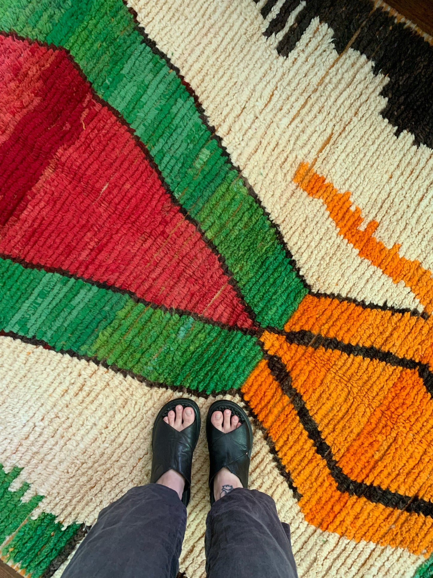 Overhead view of Sikora shows the green, orange and cream details of the woven rug.