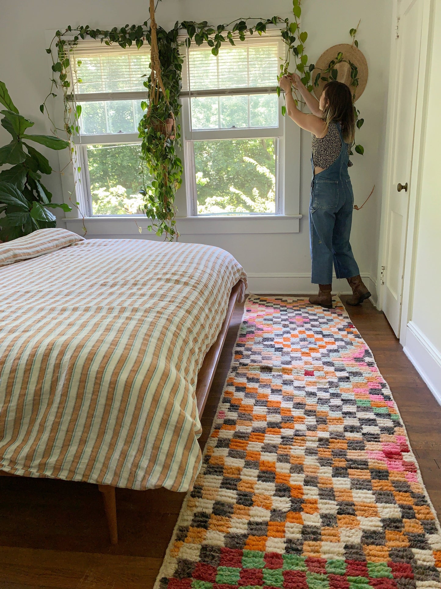 Lelo Moroccan Runner has woven checks and makes a fun statement in a bedroom with a striped bedspread.