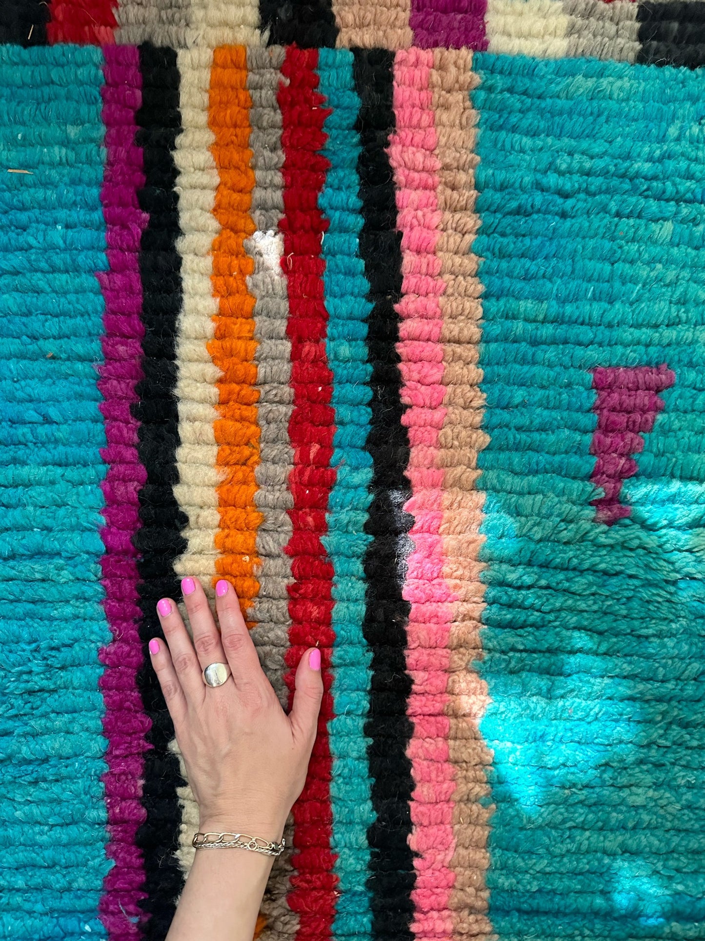 A hand on Julep Moroccan runner highlights the colorful stripes.