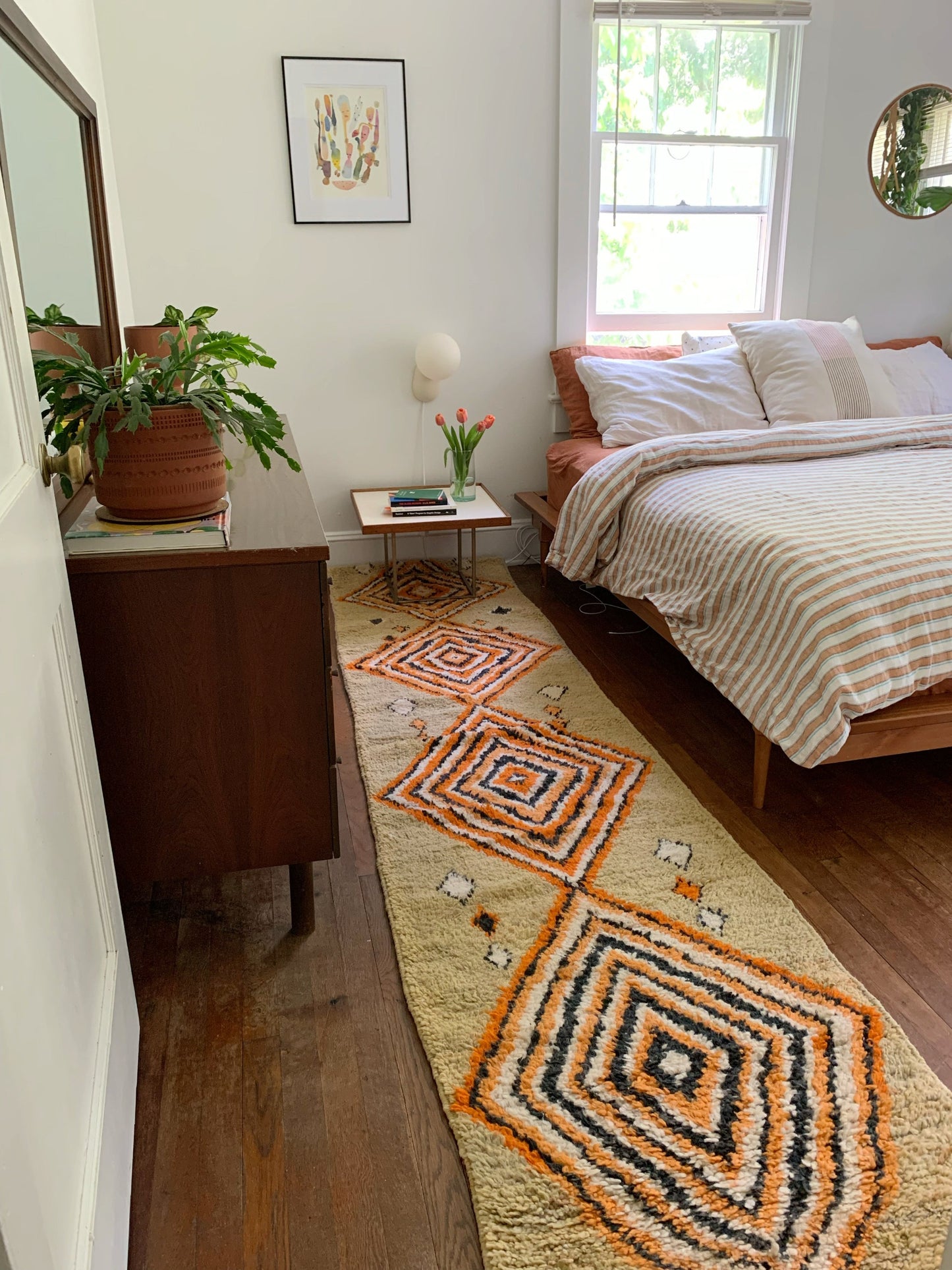 A vase of pink tulips helps complete the bedroom with Pini Moroccan Runner.