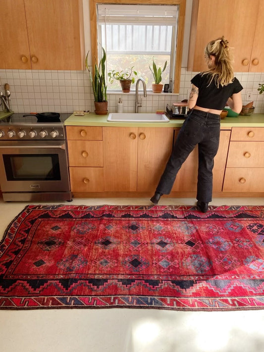 Bright red Persian rugs make a kitchen pop