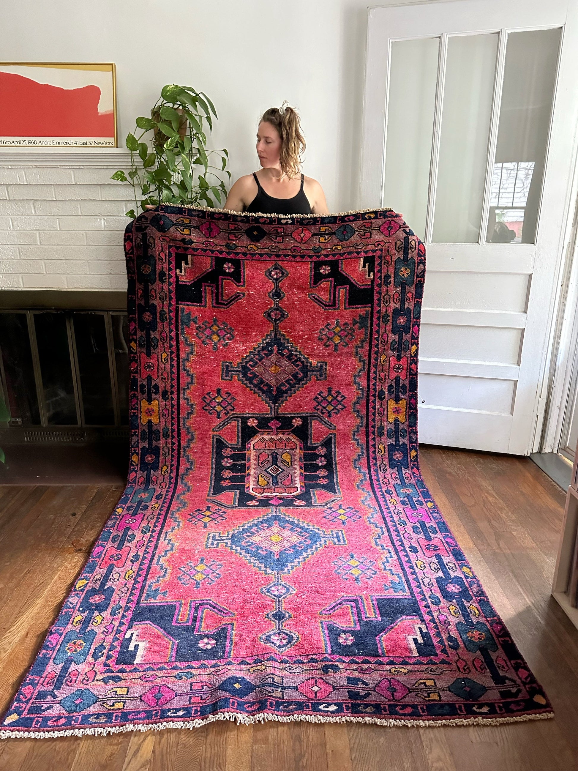 Tamarind Persian Rug is held to see the gorgeous field of motifs