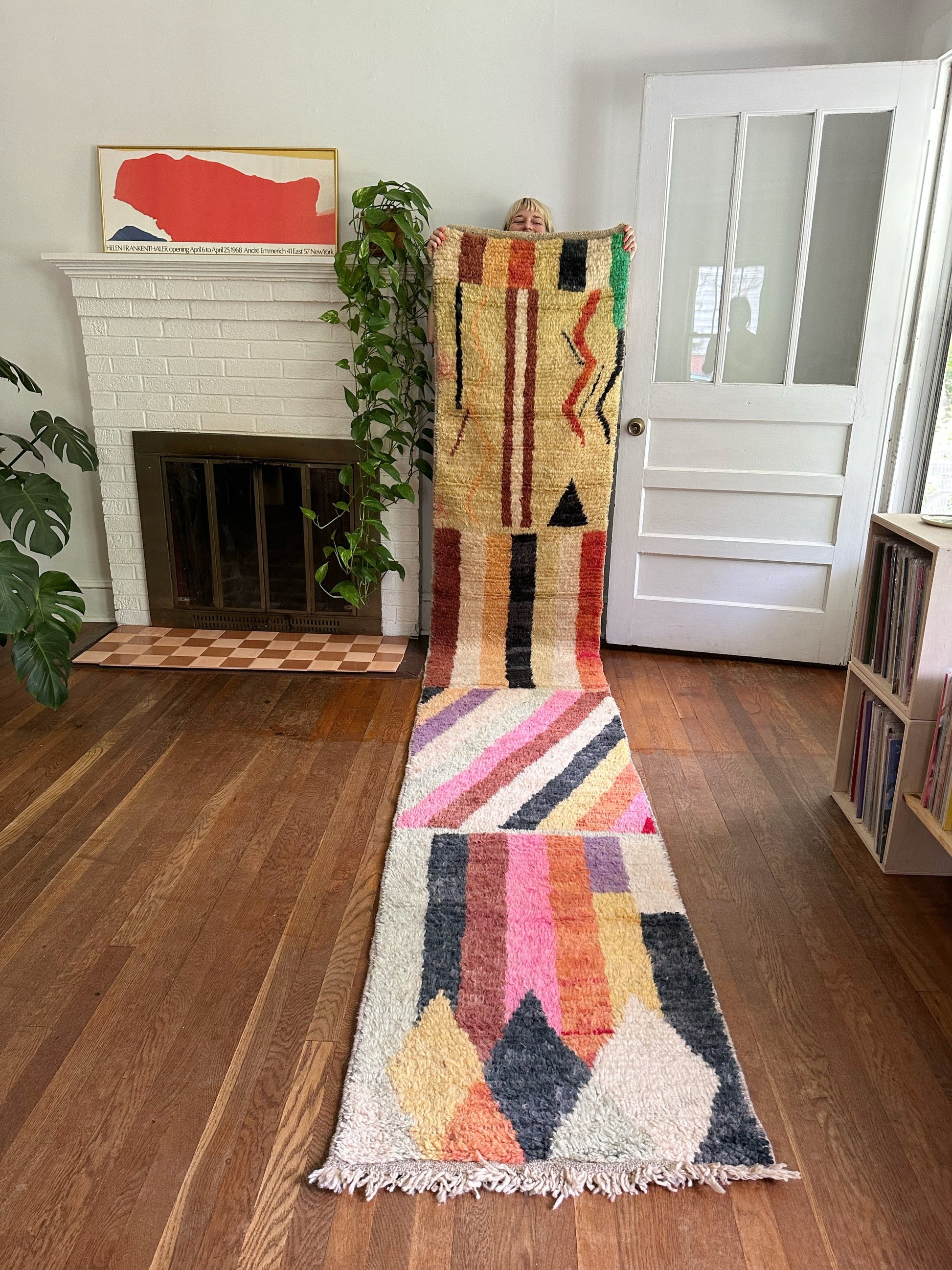 Larache Moroccan Runner is held highlighting the rainbow stripes and abstract design