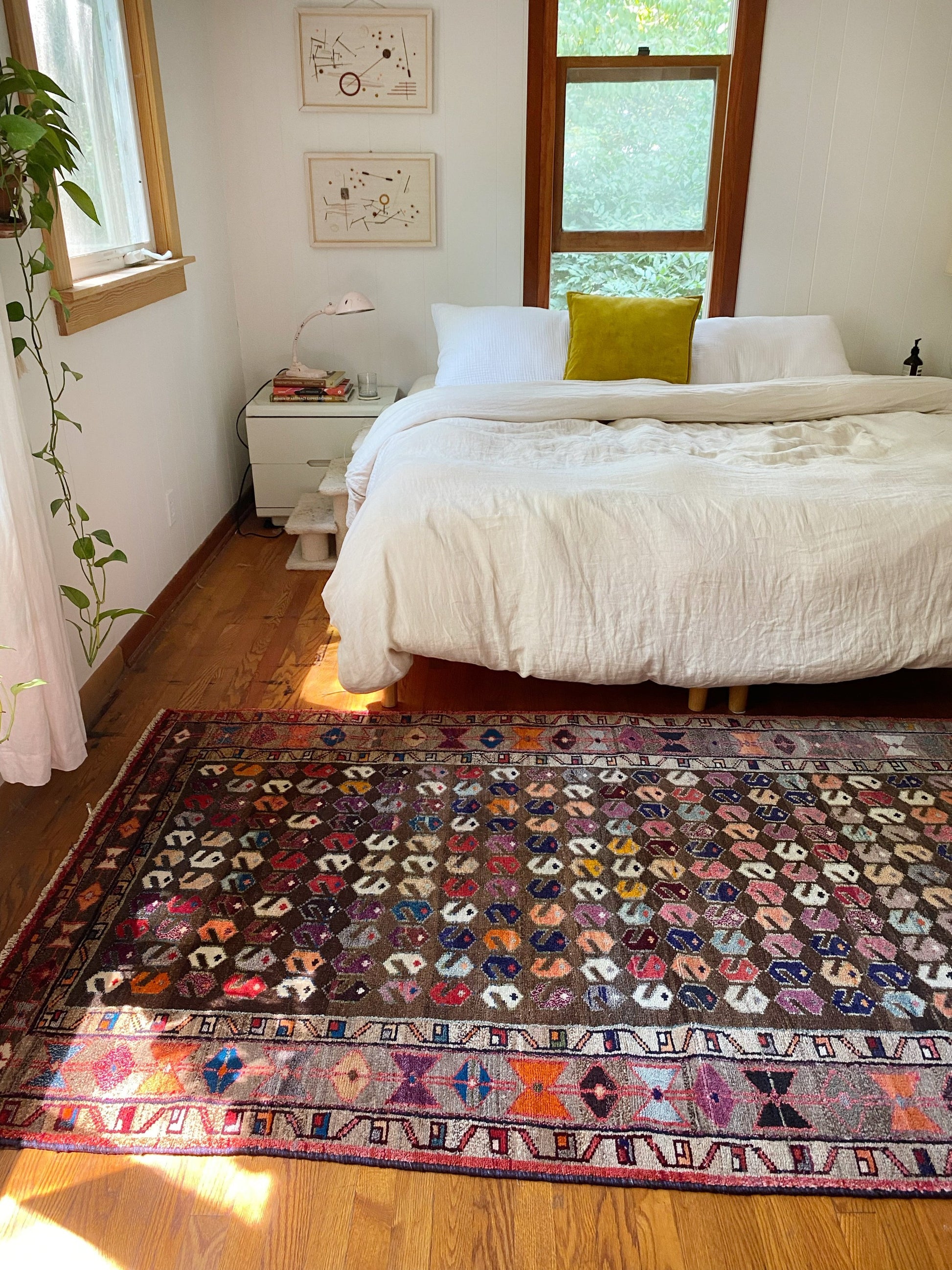 vintage persian area rug in a bedroom with a king size bed. 