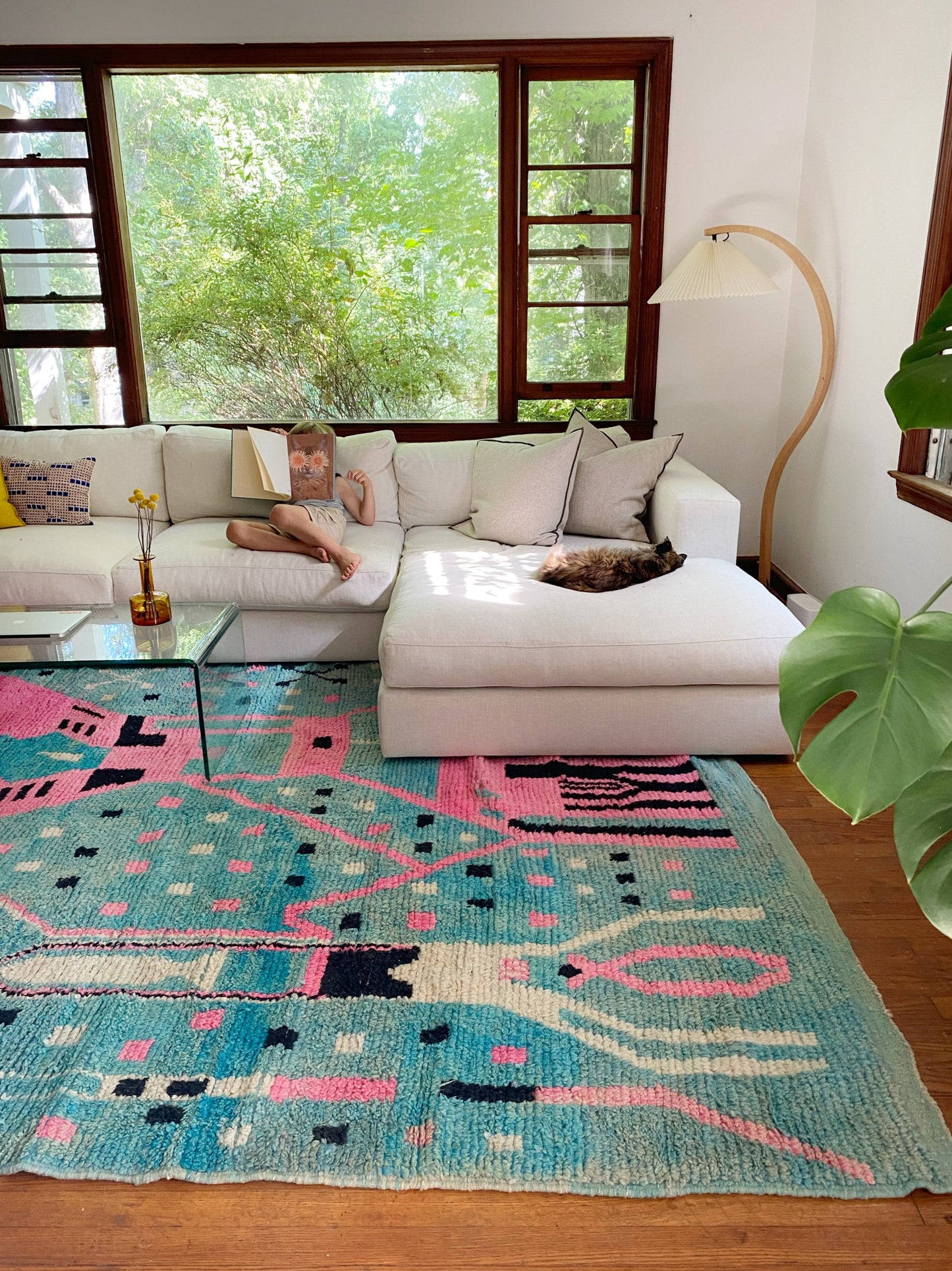 A child reads a book while a kitty snoozes near Chablis Moroccan area rug