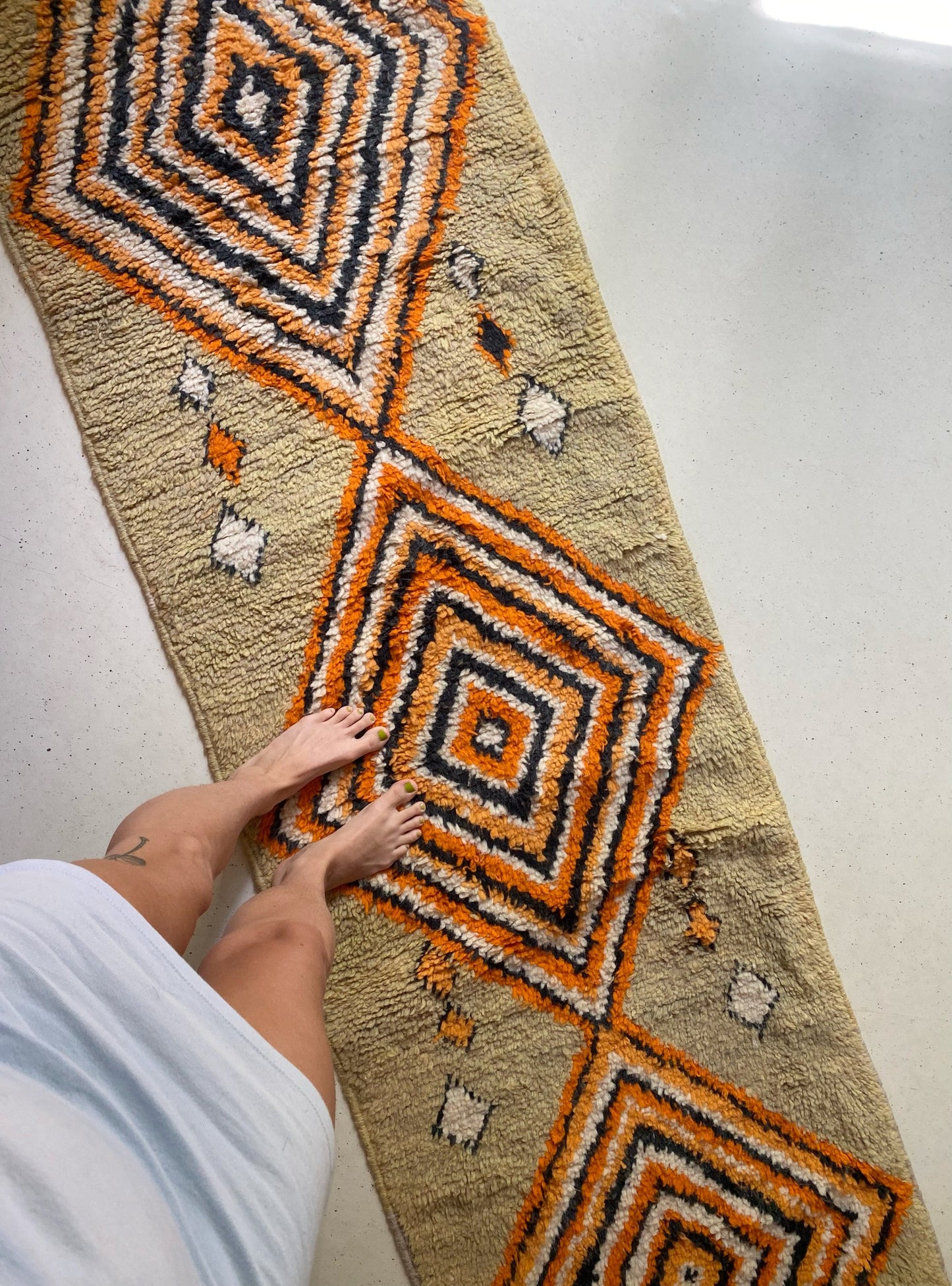 Moroccan runner hand woven with striped orange, white and black diamonds.