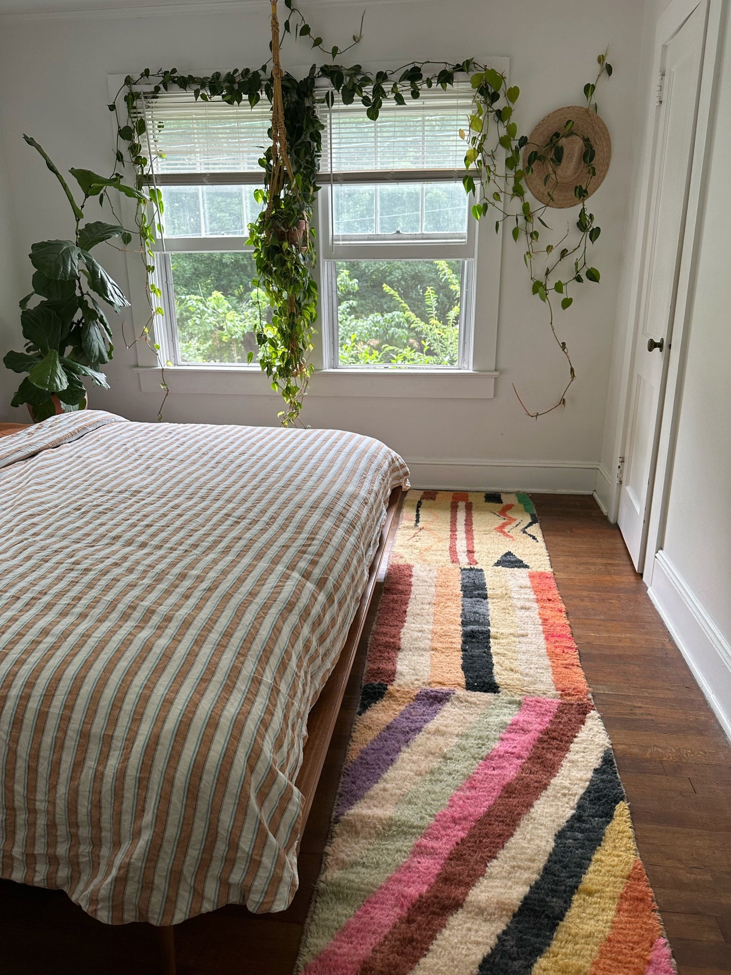 A view to a window in a bedroom with Larache Moroccan Runner at the foot of the bed.