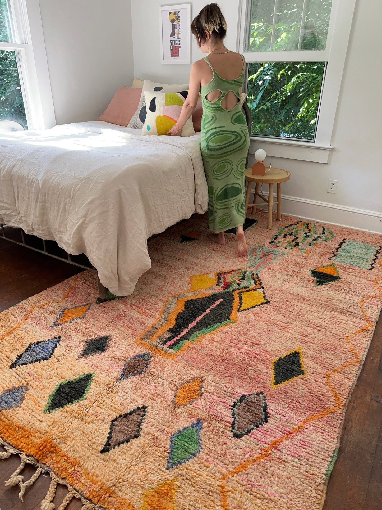 A bed is being made with Clay Moroccan Rug underfoot.