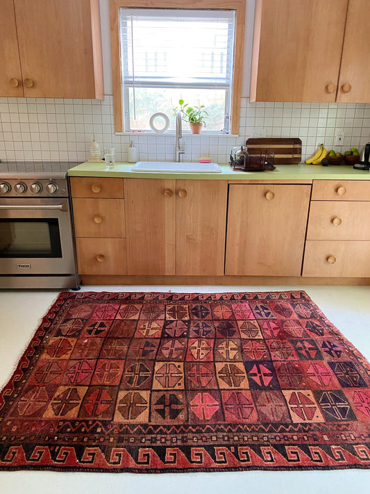 Warming tones of deep carmine and cream make this vintage Persian rug a special touch.